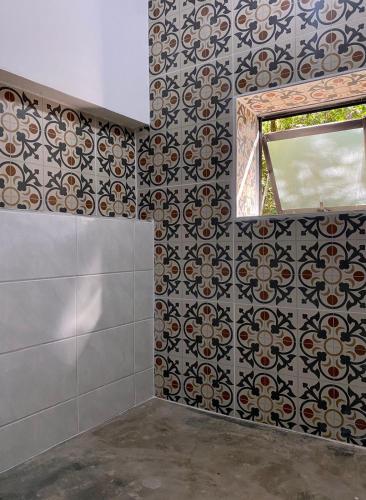 een badkamer met een tegelwand en een raam bij Casa charmosa em condomínio arborizado in Nova Lima