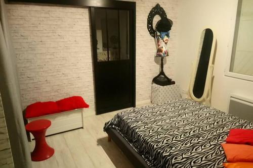 une chambre avec un lit et un mur de briques dans l'établissement Petite maison mitoyenne, proche port & Arcachon, à La Teste-de-Buch