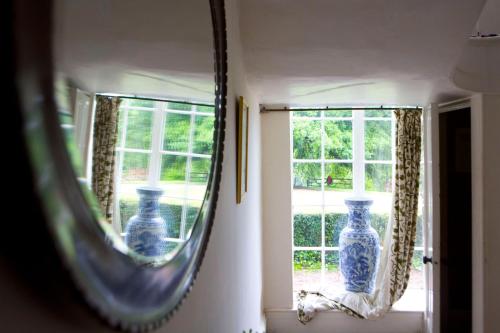 a mirror reflecting two blue vases on a window at ASHLEY COURT in Tiverton