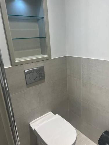 a bathroom with a white toilet and a mirror at 1 bed Apartment in Whitechapel in London