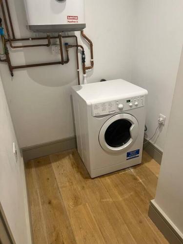 a washing machine sitting on the floor in a room at 1 bed Apartment in Whitechapel in London