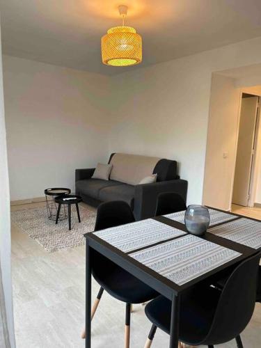 uma sala de estar com uma mesa e um sofá em Studio rénové à deux pas de la mer em Vallauris