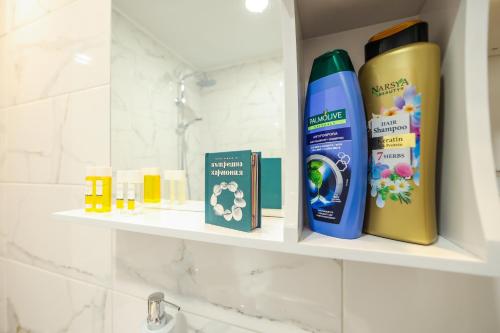 a shelf in a bathroom with products on it at Family Hotel Gotse Delchev in Gotse Delchev