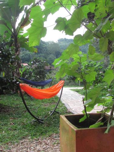 eine orangefarbene Hängematte im Gras neben einem Baum in der Unterkunft Nido de Pajaros in Portachuelo