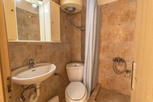 a bathroom with a toilet and a sink and a mirror at Sunday Mood in Nea Skioni
