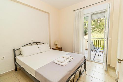a bedroom with a bed and a balcony at Sunday Mood in Nea Skioni