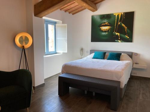 a bedroom with a bed with blue pillows at Collina d’Oro in Belforte del Chienti