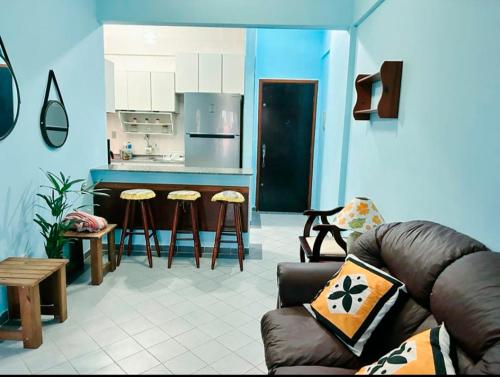 uma sala de estar com um sofá e uma cozinha em Ap beira-mar com wi-fi e garagem em Mongaguá