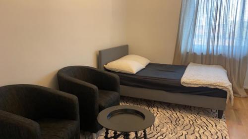 a small bedroom with a bed and a chair at Room with double Bed not all apartment in Malmö