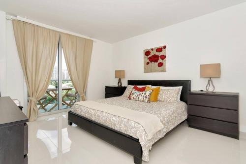 a white bedroom with a bed and a window at SPECIAL Beautiful Modern Beach Condo in Miami Beach