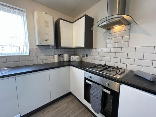 泰恩茅斯的住宿－Jacksons Modern Retreat Close to Tynemouth，厨房配有白色橱柜和炉灶烤箱。