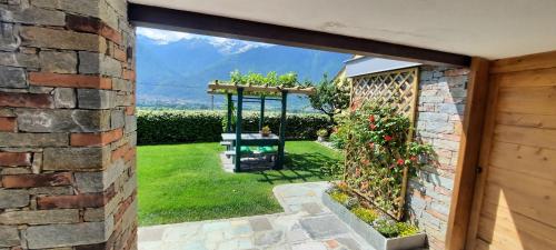 an open door to a garden with a pergola at B&B Monastero in Dubino