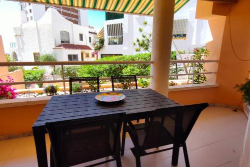 einen schwarzen Tisch und Stühle auf dem Balkon in der Unterkunft Apartamento en primera línea de playa, frente al puerto de Aguadulce in Aguadulce