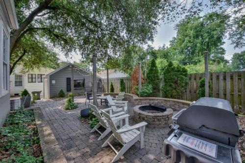 a backyard with a grill and chairs and a fire pit at Bama Hideout in Tuscaloosa