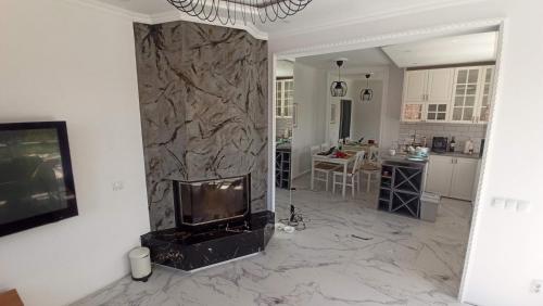 a living room with a television and a stone wall at Guesthouse Müller in Ilindentsi