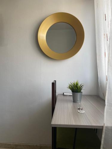 a dining room table with a gold mirror on the wall at Hostal Mediterraneo in Torre del Mar