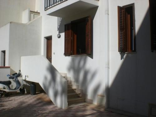 een trap naar een wit gebouw met een trap bij Casa vacanza spiaggia Praia in Favignana