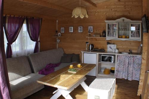 uma sala de estar com um sofá e uma mesa em Lawendowe Domki Mielno em Mielno