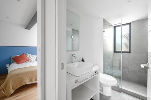 a white bathroom with a sink and a toilet at Baja California 279 Apartments in Mexico City
