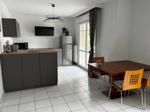 eine Küche und ein Esszimmer mit einem Tisch, einem Tisch und Stühlen in der Unterkunft L'Etoile in Lutterbach