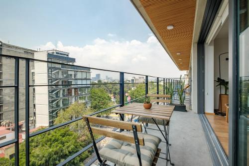 um apartamento com varanda com mesa e cadeiras de madeira em Baja California 279 Apartments em Cidade do México