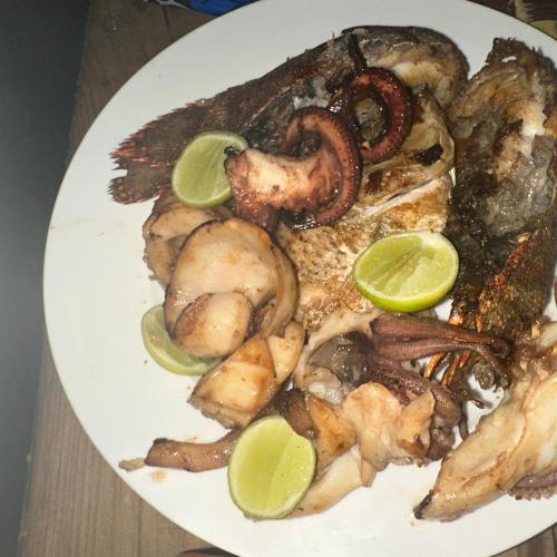 a white plate of food with shrimp and mushrooms at Stonefish Inn Jambiani in Jambiani