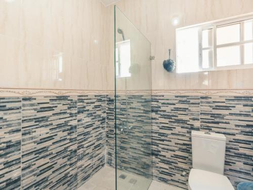 La salle de bains est pourvue de toilettes et d'une douche en verre. dans l'établissement Modern Penthouse Near The Beach Long Term Deal, à Punta Cana