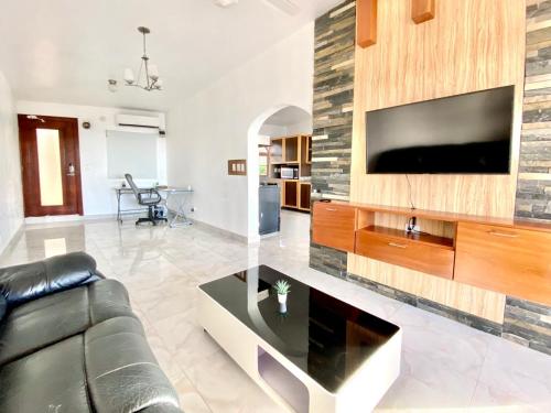 a living room with a couch and a tv on a wall at Inviting 2-Bed Apartment in Cofresi in Las Flores