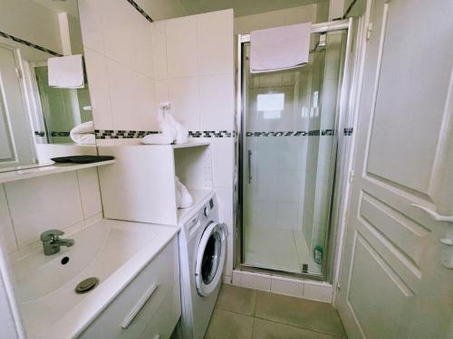 a bathroom with a shower and a washing machine at Beau Studio entre Paris et Disneyland-Proche Centrex in Noisy-le-Grand