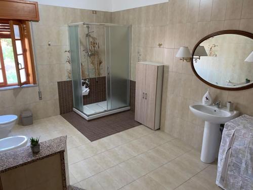 a bathroom with a shower and a sink and a mirror at Casa Vacanza Torre di Mezzo - Alba in Marausa