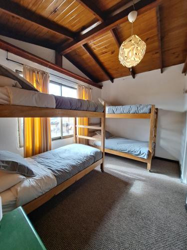 1 dormitorio con 2 literas y lámpara de araña en Hostal Boutique CUMBRES en Farellones