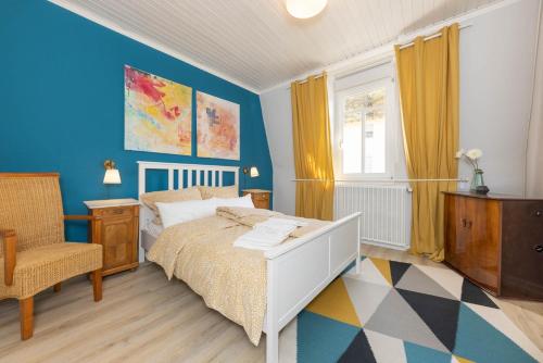 a bedroom with a bed and a chair at FerienNest Haus Braunfels in Bad Ems
