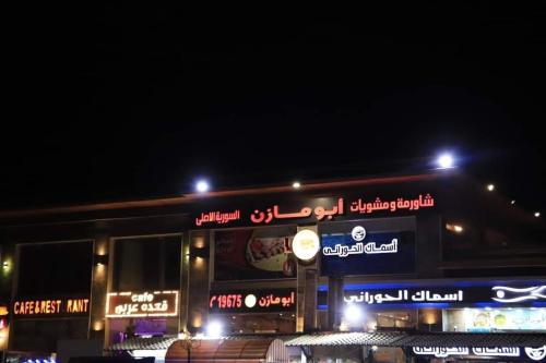 a fast food restaurant with neon signs at night at فيلا في بلو باي أسيا العين السخنة in Ain Sokhna