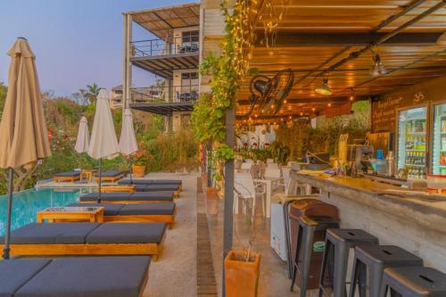 een restaurant met een zwembad en tafels en parasols bij Casa Mauna Boutique Hotel in Cuatunalco