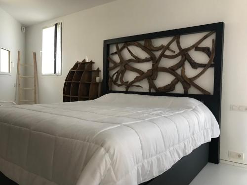 Schlafzimmer mit einem großen Bett mit einem Kopfteil aus Holz in der Unterkunft La Maison Blanche IBIZA in Ibiza-Stadt