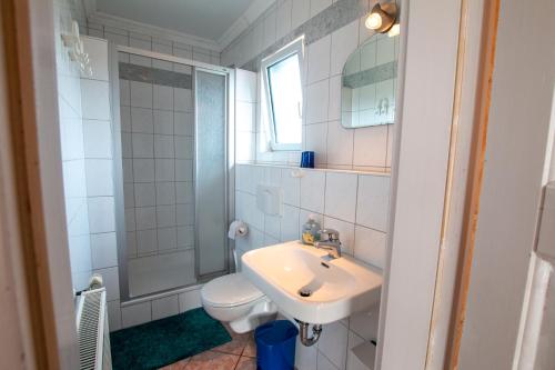 La salle de bains est pourvue d'un lavabo, de toilettes et d'un miroir. dans l'établissement Kleines Ferienhaus, à Sellin