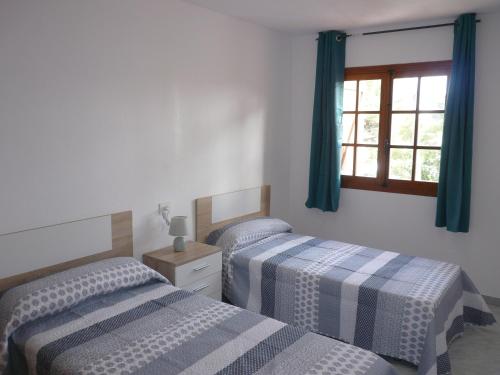 2 Einzelbetten in einem Zimmer mit Fenster in der Unterkunft Inocencia in Alcossebre