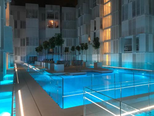 a swimming pool in a building at night at La Maison Blanche IBIZA in Ibiza Town