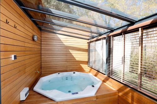 uma banheira de hidromassagem num quarto com janela em Le mazet des amants, cabane en bois avec jacuzzi privatif em Avignon
