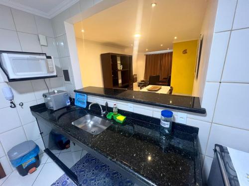 un bancone della cucina con lavandino e specchio di Trilha do Mar 207 ad Arraial do Cabo