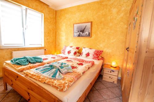 - une chambre avec un grand lit aux murs jaunes dans l'établissement Kleines Ferienhaus, à Sellin