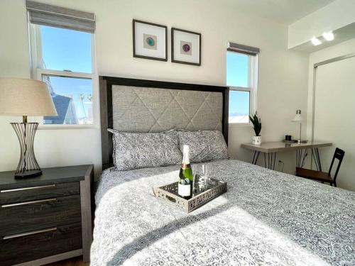 una camera da letto con un letto e una bottiglia di vino sopra di Luxury K-Town Dwelling with private rooftop deck. a Los Angeles