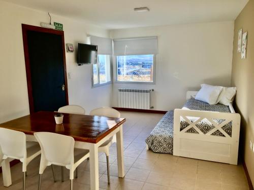 a living room with a dining room table and a bed at Go Patagonia! in El Calafate