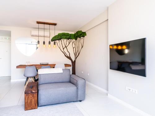 a living room with a blue chair and a table at Madeira apartment in Mindelo São Vicente in Mindelo