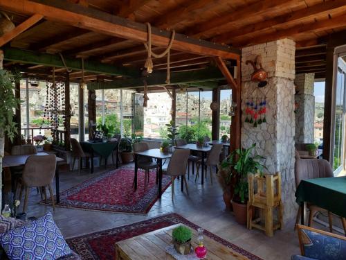 a restaurant with tables and chairs on a patio at Duru Cappadocia Stone House in Nevşehir