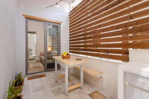 Habitación con mesa y pared de madera. en The cozy nest, en La Canea