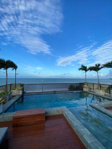 a swimming pool with a view of the ocean at Arpoar Suítes - Suíte 433 in João Pessoa