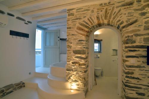 a bathroom with a stone wall and a bath tub at Villa Aerino I & ΙΙ in Kámbos