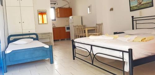 two beds in a room with a kitchen at Perasma Apartments in Kypri