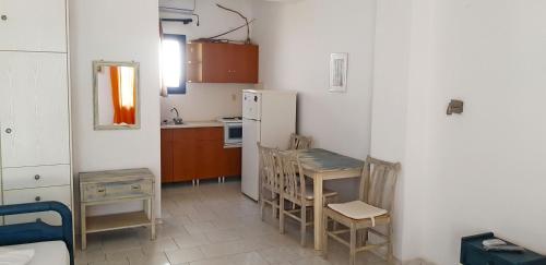 a kitchen with a table and chairs and a refrigerator at Perasma Apartments in Kypri